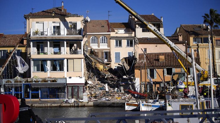Rescue workers search the rubbles at a three-story apartment building after it collapsed in a suspected gas explosion on southern Frances Mediterranean coast, Tuesday, Dec. 7, 2021 in Sanary-sur-Mer. French rescue workers dug out the body of a man but also pulled a toddler and the childs mother alive from the rubble of the building that collapsed in a suspected gas explosion. Two other people are missing. (AP Photo/Daniel Cole)
