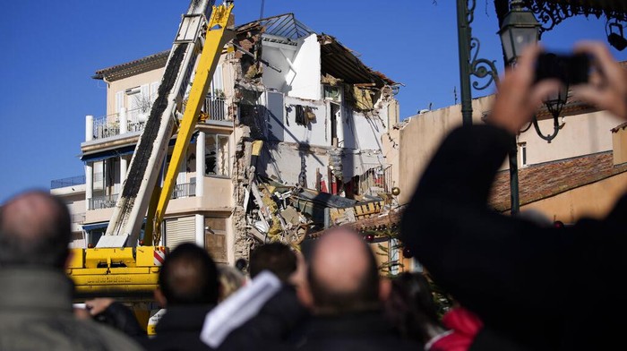 Rescue workers search the rubbles at a three-story apartment building after it collapsed in a suspected gas explosion on southern France's Mediterranean coast, Tuesday, Dec. 7, 2021 in Sanary-sur-Mer. French rescue workers dug out the body of a man but also pulled a toddler and the child's mother alive from the rubble of the building that collapsed in a suspected gas explosion. Two other people are missing. (AP Photo/Daniel Cole)