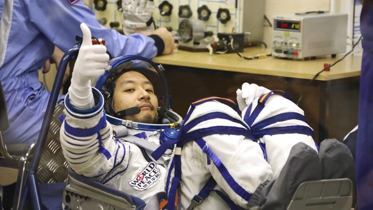 Konglomerat Jepang Wisata ke Luar Angkasa Dalam foto yang dirilis oleh Badan Antariksa Roscosmos, peserta penerbangan luar angkasa Yusaku Maezawa dari Jepang, anggota kru utama misi Soyuz baru ke Stasiun Luar Angkasa Internasional (ISS) memberi isyarat sebelum peluncuran di kosmodrom Baikonur yang disewa Rusia, Kazakhstan, Rabu, 8 Desember 2021. (Pavel Kassin, Badan Antariksa Roscosmos via AP)
