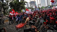 Massa buruh menarik kawat duri saat unjuk rasa di kawasa Patung Kuda, Jakarta Pusat, Rabu (8/12/2021). 