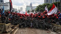 Sejumlah orang memanfaatkan batang bambu yang pucuknya dipasangi bendera Merah Putih untuk membuka kawat berduri. 