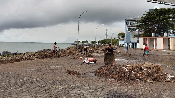 Petugas kebersihan mengumpulkan dan mengangkut sampah-sampah yang terbawa banjir rib di kawasan Megamas, Manado, Sulut.