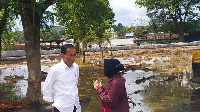 Presiden Jokowi (kiri) bersama Mensos Tri Rismaharini (kanan) di sekitar lokasi pembangunan tanggul di Kelurahan Ladang Sintang Kalimantan Barat, Rabu (8/12/2021). (ANTARA/Teofilusianto Timotius)