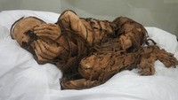 A mummy from 800-1200 AD is displayed at San Marcos University in Lima, Peru, Tuesday, Dec. 7, 2021. According to archeologists, the mummy was buried with its hands covering its face and wrapped with rope in Cajamarquilla, near Perus Capital. (AP Photo/Martin Mejia)