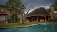 Awan badai bergerak di atas Tamboti Bush Lodge di cagar alam Dinokeng dekat Hammanskraal, Afrika Selatan. Resor itu nampak sepi.