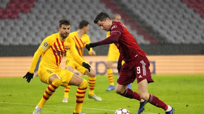 Barcelonas Gerard Pique, left, defends against Bayerns Robert Lewandowski during the Champions League group E soccer match between Bayern Munich and FC Barcelona in Munich, Germany, Wednesday, Dec. 8, 2021. (AP Photo/Matthias Schrader)