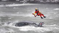 Proses evakuasi ini berlangsung dramatis dengan seorang petugas penyelamat yang tergantung dari helikopter milik Penjaga Pantai setempat, mendekati mobil yang nyaris tenggelam itu dari udara, dengan arus sungai yang sangat deras di bawahnya. (AP/Sharon Cantillon)