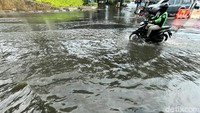 Seorang pengendara motor melintasi Jalan MT Haryono Cawang, yang tergenang usai diguyur hujan.