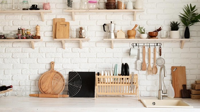 Rustic kitchen interior with brick wall and white wooden shelves, front view