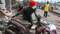 Anggota Komando Pasukan Khusus (Kopassus) TNI Angkatan Darat turut membantu mengevakuasi sepeda motor milik warga terdampak letusan gunung Semeru yang rusak di dusun Sumbersari, Pronojiwo, Lumajang, Jawa Timur, Kamis (9/12/2021).( ANTARA FOTO/Ari Bowo Sucipto).