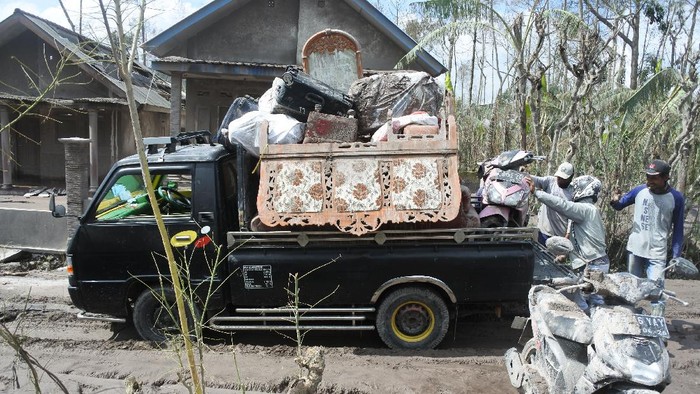 Sejumlah warga kembali ke rumah mereka yang hancur akibat erupsi Gunung Semeru di Lumajang. Mereka menyelamatkan barang-barang yang tersisa.