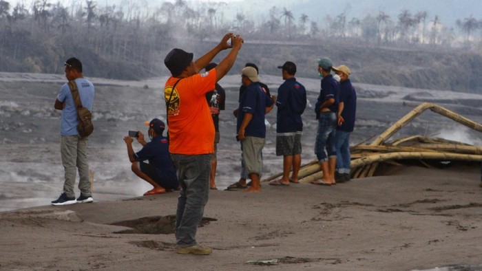 Wisatawan melihat dari dekat lokasi bencana letusan gunung Semeru di dusun Sumbersari, Pronojiwo, Lumajang, Jawa Timur, Kamis (9/12/2021). Sejumlah wisatawan tetap nekat mendekati lokasi jalur aliran lahar untuk berswafoto dan membuat konten media sosial meskipun sudah diperingatkan tentang bahaya banjir lahar hujan yang masih berpotensi terjadi. ANTARA FOTO/Ari Bowo Sucipto/hp.