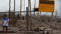 Wisatawan menerobos penghalang jalan untuk melihat dari dekat lokasi bencana letusan gunung Semeru di dusun Sumbersari, Pronojiwo, Lumajang, Jawa Timur.