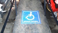 Warga berjalan di dekat jalur khusus penyandang disabilitas di Pasar Gunung Batu, Kota Bogor, Jawa Barat, Kamis (9/12/2021).