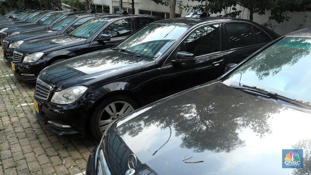Pekerja merapihkan mobil eks-taksi yang akan dijual di showroom mobil Bluebird di kawasan Warung Buncit, Jakarta Selatan, Kamis (9/12/2021).  Mobil bekas armada taksi merupakan alternatif menarik bagi Anda yang berminat untuk mendapatkan kendaraan dengan harga lebih terjangkau. (CNBC Indonesia/Andrean Kristianto)