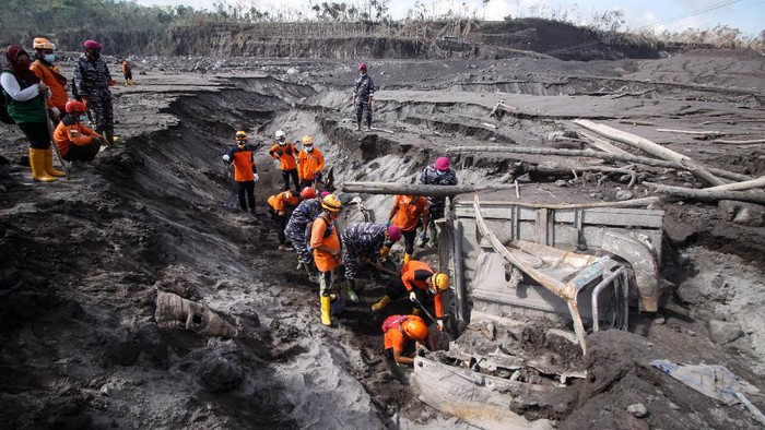Petugas kepolisian bersama anjing pelacak melintas di jalur material guguran awan panas Gunung Semeru di Curah Koboan, Pronojiwo, Jawa Timur, Kamis (9/12/2021). Pencarian korban guguran awan panas Gunung Semeru difokuskan di sejumlah titik di antaranya Kajar Kuning, Sumber Wuluh, Curah Koboan dan Pronojiwo. ANTARA FOTO/Umarul Faruq/hp.