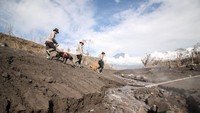Petugas kepolisian bersama anjing pelacak melintas di jalur material guguran awan panas Gunung Semeru di Curah Koboan, Pronojiwo, Jawa Timur. Pencarian korban guguran awan panas Gunung Semeru difokuskan di sejumlah titik.