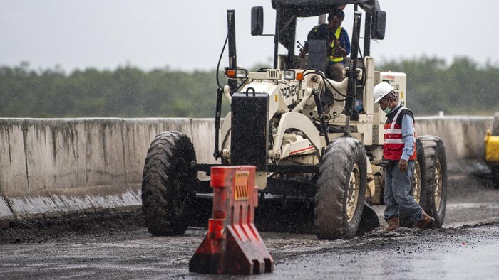 PERBAIKAN JALAN TOL TRANS SUMATERA Pekerja dengan menggunakan alat berat menyelesaikan perbaikan Jalan Tol Trans Sumatera ruas Kayu Agung-Pematang Panggang-Terbanggi Besar KM 310, Ogan Komering Ilir (OKI), Sumatera Selatan, Kamis (9/12/2021). Perbaikan jalan tersebut dilakukan jelang libur Natal dan pergantian tahun yang diprediksi akan mengalami lonjakan pengguna tol. ANTARA FOTO/Nova Wahyudi/rwa.