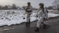 Dua orang tentara Ukraina berjalan di garis pemisah dari pemberontak pro-Rusia di dekat Katerinivka, wilayah Donetsk, Ukraina, Selasa (7/12/2021). Ukraina bersiap menghadapi ancaman serangan Rusia di negaranya. AP Photo/Andriy Dubchak.
