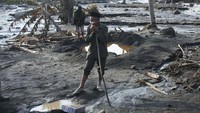 Seorang warga berada di samping rumah saudarannya yang hancur dan tertimbun material Gunung Semeru di Kampung Renteng, Desa Sumberwuluh, Candipuro, Lumajang, Jawa Timur, Kamis (9/12/2021).