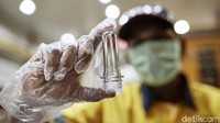 Petugas mengecek sampel minuman untuk diuji.