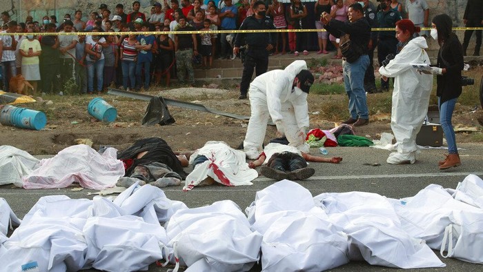 49 Migran Ilegal Tewas Kecelakaan di Meksiko The body of a man lies on the side of the road next to the overturned truck on which he was traveling near Tuxtla Gutierrez, Chiapas state, Mexico, Thursday, Dec. 9, 2021. Mexican authorities say at least 49 people were killed and dozens more injured when the truck carrying the migrants rolled over on the highway in southern Mexico. (AP Photo)