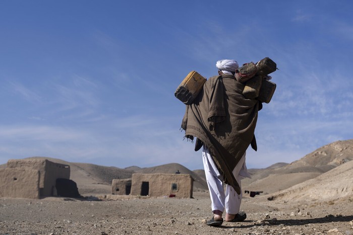 The granddaughter of Hajji Wali Jan, 66, stands at the entrance of her house in Kamar Kalagh village outside Herat, Afghanistan, Friday, Nov. 26, 2021. Afghanistan’s drought, its worst in decades, is now entering its second year, exacerbated by climate change. (AP Photo/Petros Giannakouris)