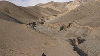 Kakak beradik berlarian menuju sumber air yang tersisa di tengah pegunungan tandus di desa Kamar Kalagh, Herat, Afghanistan. Herat berada jauh dari Ibu Kota Kabul, sekitar 840 km sebelah barat.