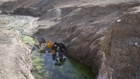 Kakak beradik mengambil air bersih yang tersisa di tengah pegunungan tandus di desa Kamar Kalagh, di provinsi paling barat Afghanistan, Herat, (26/11/2021).