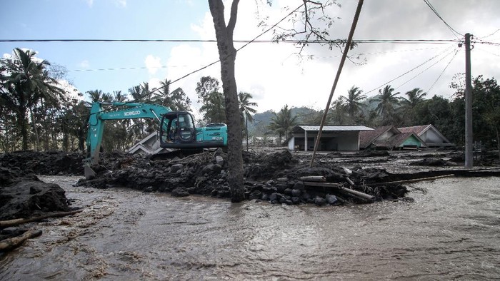 Alat Berat Dikerahkan untuk Bersihkan Material Erupsi Semeru Petugas mengoperasikan ekskavator untuk membersihkan material erupsi Gunung Semeru yang menutupi jalan di Dusun Kamar Kajang, Sumberwuluh, Candipuro, Lumajang, Jawa Timur, Jumat (10/12/2021). Pembersihan material pasir dan batu dari letusan Gunung Semeru tersebut dilakukan untuk memperlancar proses evakuasi korban di wilayah itu. ANTARA FOTO/Umarul Faruq/rwa.