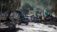 Anggota TNI dari Batalyon Zeni Tempur (Yonzipur) 10 Komando Cadangan Strategis Angkatan Darat (Kostrad) menggunakan alat berat untuk membersihkan material pasir Gunung Semeru yang menutupi jalan di Dusun Kamar Kajang, Candipuro, Lumajang, Jawa Timur.