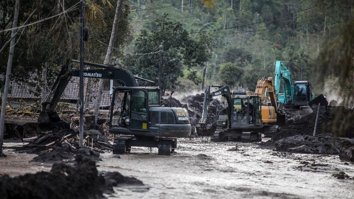 Alat Berat Dikerahkan untuk Bersihkan Material Erupsi Semeru Petugas mengoperasikan ekskavator untuk membersihkan material erupsi Gunung Semeru yang menutupi jalan di Dusun Kamar Kajang, Sumberwuluh, Candipuro, Lumajang, Jawa Timur, Jumat (10/12/2021). Pembersihan material pasir dan batu dari letusan Gunung Semeru tersebut dilakukan untuk memperlancar proses evakuasi korban di wilayah itu. ANTARA FOTO/Umarul Faruq/rwa.