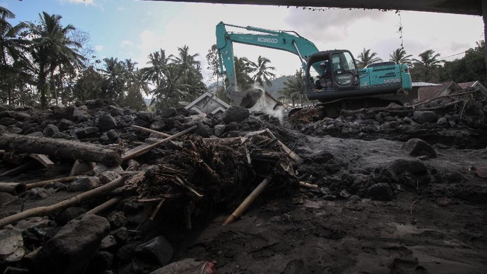 Alat Berat Dikerahkan untuk Bersihkan Material Erupsi Semeru Petugas mengoperasikan ekskavator untuk membersihkan material erupsi Gunung Semeru yang menutupi jalan di Dusun Kamar Kajang, Sumberwuluh, Candipuro, Lumajang, Jawa Timur, Jumat (10/12/2021). Pembersihan material pasir dan batu dari letusan Gunung Semeru tersebut dilakukan untuk memperlancar proses evakuasi korban di wilayah itu. ANTARA FOTO/Umarul Faruq/rwa.