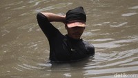 Setelah menjaring lumpur yang bercampur cacing, jaring itu harus digoyang-goyang ke aliran sungai agar lumpur hilang dan cacing bisa dipisahkan ke karung yang sudah dibawa.  