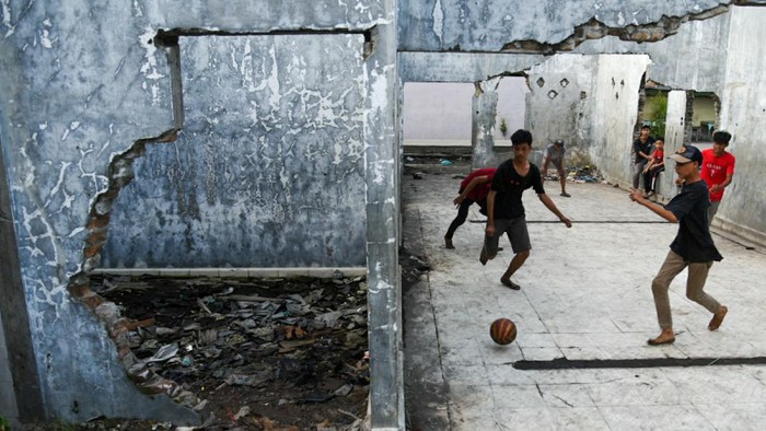 Sejumlah anak bermain sepak bola di dalam rumah terbengkalai di kawasan Belawan, Medan, Sumatera Utara, Kamis (9/12/2021). Minimnya tempat bermain di kawasan tersebut membuat mereka memanfaatkan tempat yang tidak semestinya untuk bermain. ANTARA FOTO/Fransisco Carolio/Lmo/rwa.