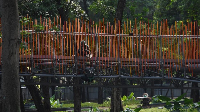 PEMBANGUNAN TEBET ECO GARDEN Pekerja menyelesaikan pembuatan jembatan penghubung taman selatan dan utara pada revitalisasi taman tebet menjadi Tebet Eco Garden di Jakarta, Kamis (9/12/2021). Pembangunan Tebet Eco Garden direncanakan memiliki fasilitas jembatan penghubung, area bermain anak, community garden, thematic garden dan sarana olahraga. ANTARA FOTO/Hafidz Mubarak A