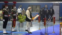 Perdana Menteri India Narendra Modi memberikan penghormatan terakhir kepada peti mati panglima militer yang terbungkus bendera, Jenderal Bipin Rawat dan lainnya setelah mereka tiba di bandara Palam di New Delhi, India. (AP/Manish Swarup)