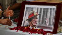 Seorang pria meletakkan lilin di depan potret panglima militer India, Jenderal Bipin Rawat, yang tewas dalam kecelakaan helikopter Rabu bersama 12 orang lainnya di negara bagian Tamil Nadu selatan. (AP/Ajit Solanki)