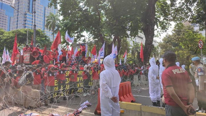 Petugas Ber-APD mengamankan demo buruh di Patung Kuda, Jumat (10/12/2021).