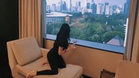 Saat sedang staycation di hotel, Anggy menatap hiruk pikuk kota Jakarta dengan segelas wine yang dinikmatinya. Foto: Instagram @anggynovia_