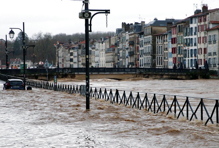 Cars on a flooded street caused by heavy rain in Bayonne, southwestern France, Friday, Dec. 10, 2021. Southwestern France is on alert for violent storms, high winds and floods. (AP Photo/Bob Edme)