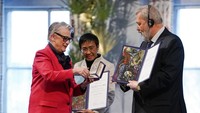 Ketua Komite Nobel, Berit Reiss-Andersen (kiri) menyerahkan piagam dan plakat dalam seremoni pemberian Nobel Perdamaian di Balai Kota Oslo, Norwegia (10/12/2021) malam.  (Stian Lysberg Solum/Pool via AP)