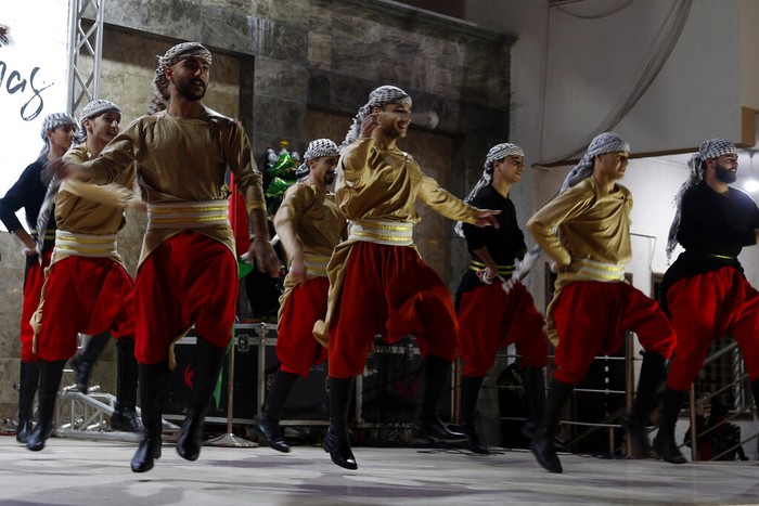 Palestinians Christmas Palestinians wear traditional uniforms perform a traditional folklore dance, Dabka, during while Christians celebrate lighting of the Christmas tree at the yard of Christian youth center in Gaza City, Friday, Dec. 10, 2021. (AP Photo/Adel Hana)
