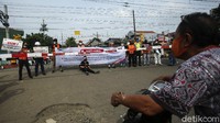 Para pengendara mengantre untuk menunggu kereta api melintas di perlintasan Bukit Duri. 