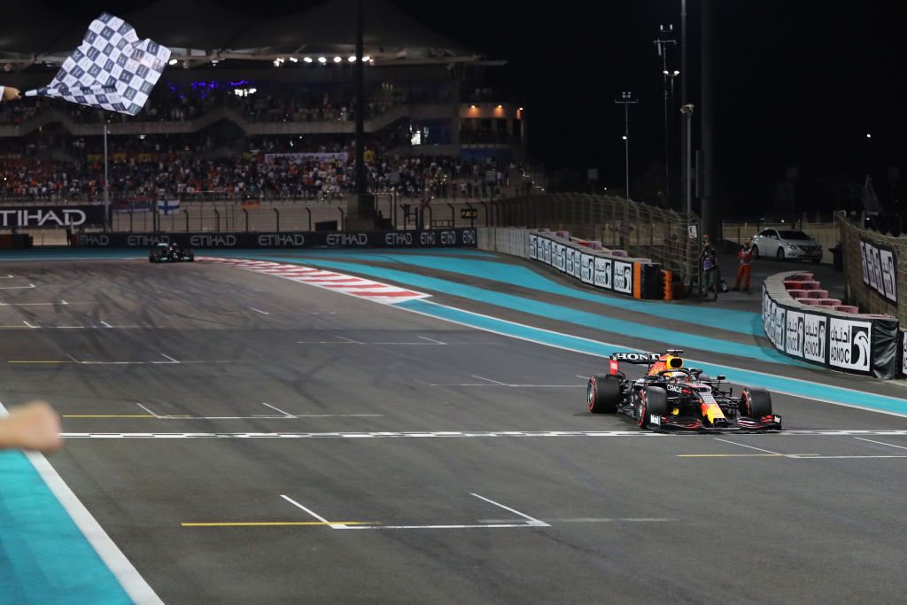 ABU DHABI, UNITED ARAB EMIRATES - DECEMBER 12: Race winner Max Verstappen of the Netherlands driving the (33) Red Bull Racing RB16B Honda takes the chequered flag during the F1 Grand Prix of Abu Dhabi at Yas Marina Circuit on December 12, 2021 in Abu Dhabi, United Arab Emirates. (Photo by Kamran Jebreili - Pool/Getty Images)