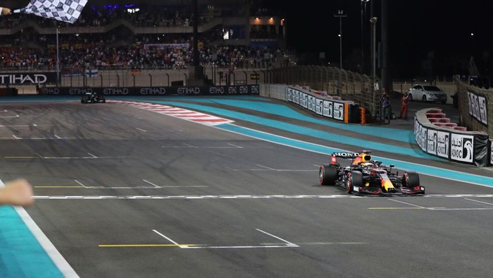 ABU DHABI, UNITED ARAB EMIRATES - DECEMBER 12: Race winner Max Verstappen of the Netherlands driving the (33) Red Bull Racing RB16B Honda takes the chequered flag during the F1 Grand Prix of Abu Dhabi at Yas Marina Circuit on December 12, 2021 in Abu Dhabi, United Arab Emirates. (Photo by Kamran Jebreili - Pool/Getty Images)