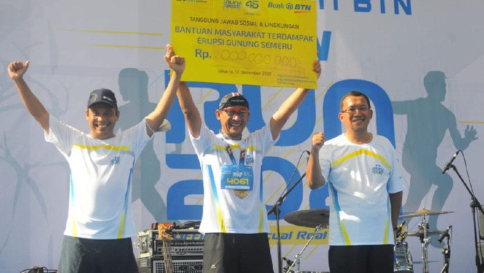 BTN Run Donasi untuk Bencana Semeru Direktur Utama PT Bank Tabungan Negara (Persero) Haru Koesmahargyo (ketiga dari kiri), Komisaris Bank BTN, Iqbal Latanro (kedua dari kiri) dan Wakil Direktur Utama Bank BTN, Nixon LP Napitupulu (kiri) mengangkat bendara start atau flag off saat acara BTN RUN 2021 Charity For Semeru dalam rangka HUT KPR 45 Semeru di Serpong, Banten, Minggu (12/12). Acara BTN RUN 2021 yang diselenggarakan sesuai prokes tersebut diikuti sekitar 2.000 peserta baik yang hadir langsung maupun yang lari secara virtual. Seluruh Peserta BTN Run yang sudah mengikuti test antigen juga turut menyumbangkan 45.000 rupiah per 1 kilometernya untuk korban bencana erupsi Gunung Semeru dengan total sumbangan mencapai Rp 1 miliar.