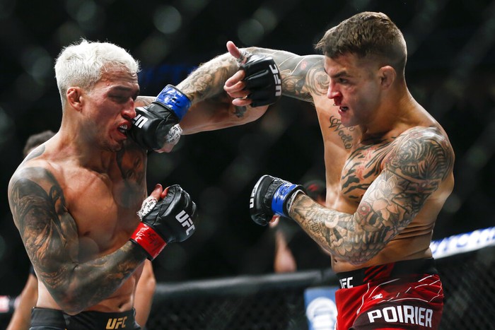 Charles Oliveira, left, fights Dustin Poirier during a lightweight mixed martial arts title bout at UFC 269, Saturday, Dec. 11, 2021, in Las Vegas. (AP Photo/Chase Stevens)