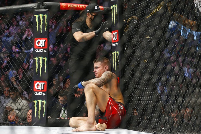 Dustin Poirier sits after losing via submission to Charles Oliveira in a lightweight mixed martial arts title bout at UFC 269, Saturday, Dec. 11, 2021, in Las Vegas. (AP Photo/Chase Stevens)