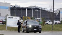 Petugas berdiri di depan fasilitas Amazon yang rusak. Daniel Shular/St. Louis Post-Dispatch via AP.